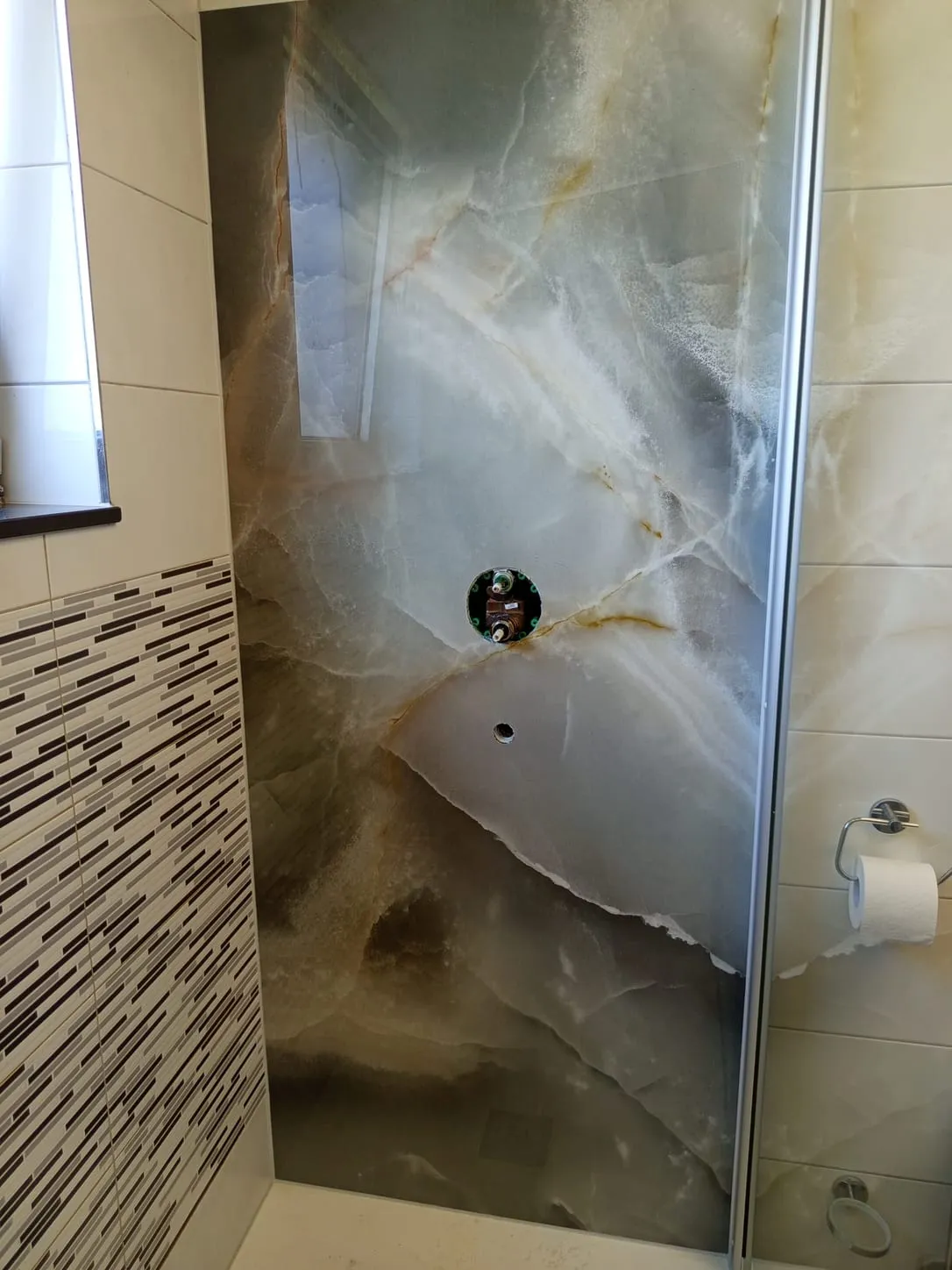 Dusche mit großformatiger Wandfliese in Onyx-Optik und Glasabtrennung