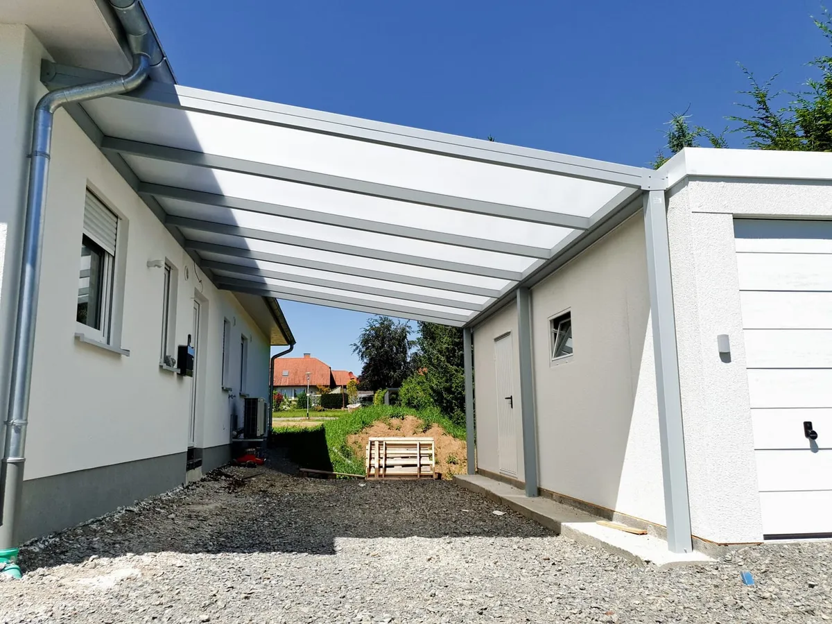 Aluminium-Überdachung mit lichtdurchlässiger Eindeckung als Carport zwischen Wohnhaus und Garage